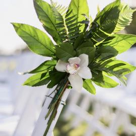Orchid and greenery on wedding ceremony chair