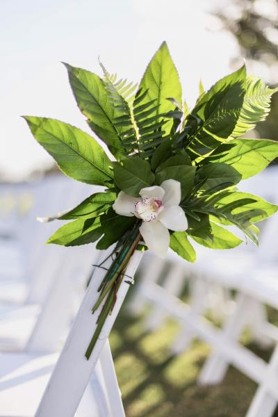 Orchid and greenery on wedding ceremony chair